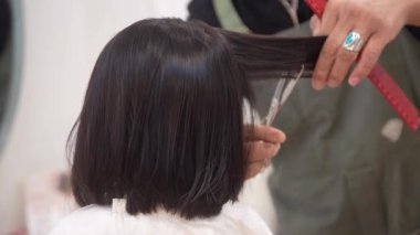 Güzellik salonunda saçını kestiren bir kız.