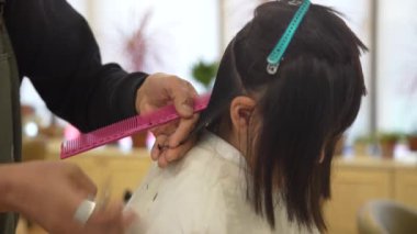 Güzellik salonunda saçını kestiren bir kız.