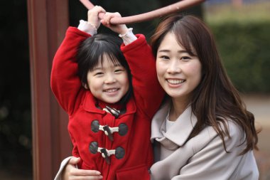 Ebeveynler ve çocuklar parkta oynuyorlar.