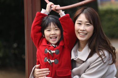 Ebeveynler ve çocuklar parkta oynuyorlar.