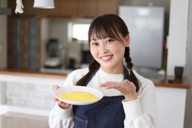 Omlet tutan bir kadın resmi.