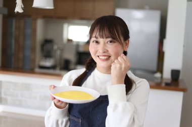 Omlet tutan bir kadın resmi.