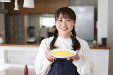 Omlet tutan bir kadın resmi.