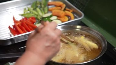 Sebze kızartan bir kadın.