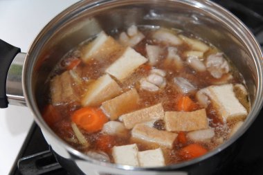 Tavuk budu, bambu filizleri ve bol yağda kızartılmış tofu güveci.