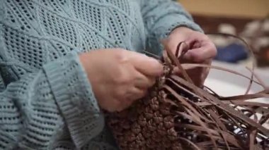 El işi bandıyla çanta yapan bir kadın.