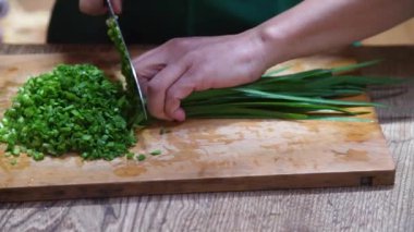 Çin soğanı kesen bir kadın.