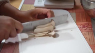 Bıçakla mantar kesen bir kadın.