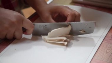 Bıçakla mantar kesen bir kadın.