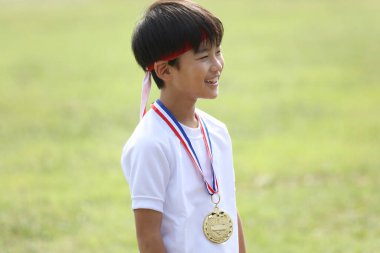 Madalya takan gülümseyen çocuk.