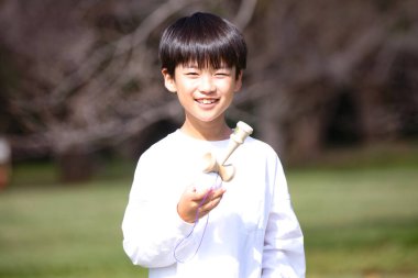 Kendama çalışan bir çocuk.