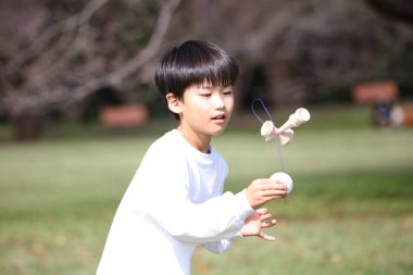 Kendama çalışan bir çocuk.