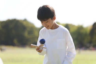 Kendama çalışan bir çocuk.