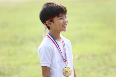 Madalya takan gülümseyen çocuk.