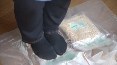 Bir kadın haşlanmış soya fasulyesini eziyor ve eziyor.