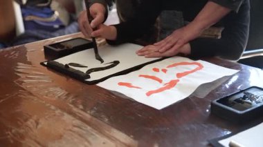 Kaligrafi dersinde hat çalışması yapan bir çocuk.