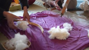 Pamukla pamuk atan bir kadın.