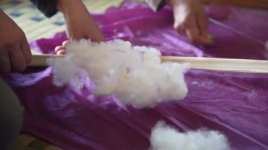 Pamukla pamuk atan bir kadın.