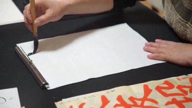 Bir kadın bir kağıt parçasını buruşturur.