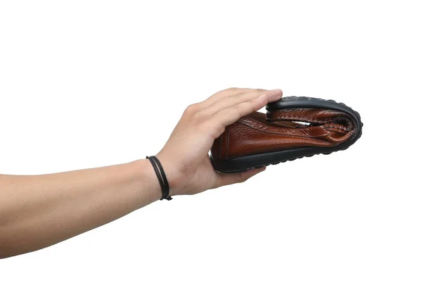 tan leather loafer holds in man hand