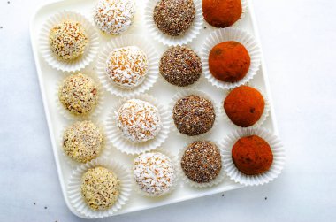 Çeşitli vejetaryen tatlılar, tohumlu lezzetli şeker topları, kurutulmuş meyve ve kakao tozu, Chia ile sağlıklı şeker, Susam tohumu, Hindistan cevizi ve yer mantarı.