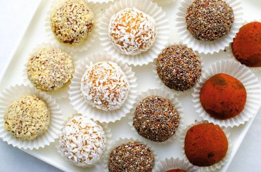 Çeşitli vejetaryen tatlılar, tohumlu lezzetli şeker topları, kurutulmuş meyve ve kakao tozu, Chia ile sağlıklı şeker, Susam tohumu, Hindistan cevizi ve yer mantarı.