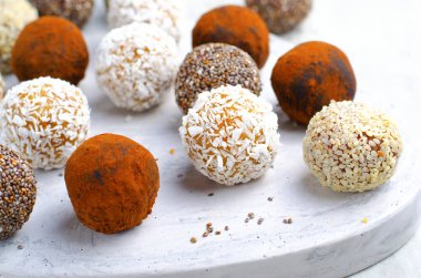 Çeşitli vejetaryen tatlılar, tohumlu lezzetli şeker topları, kurutulmuş meyve ve kakao tozu, Chia ile sağlıklı şeker, Susam tohumu, Hindistan cevizi ve yer mantarı.