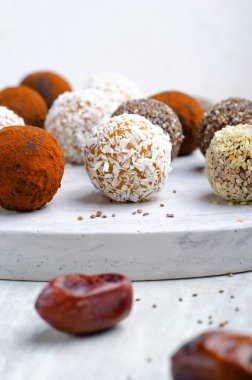 Çeşitli vejetaryen tatlılar, tohumlu lezzetli şeker topları, kurutulmuş meyve ve kakao tozu, Chia ile sağlıklı şeker, Susam tohumu, Hindistan cevizi ve yer mantarı.