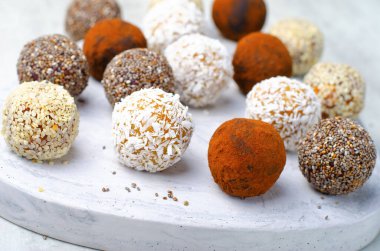 Çeşitli vejetaryen tatlılar, tohumlu lezzetli şeker topları, kurutulmuş meyve ve kakao tozu, Chia ile sağlıklı şeker, Susam tohumu, Hindistan cevizi ve yer mantarı.