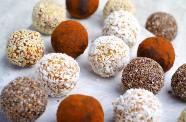 Çeşitli vejetaryen tatlılar, tohumlu lezzetli şeker topları, kurutulmuş meyve ve kakao tozu, Chia ile sağlıklı şeker, Susam tohumu, Hindistan cevizi ve yer mantarı.