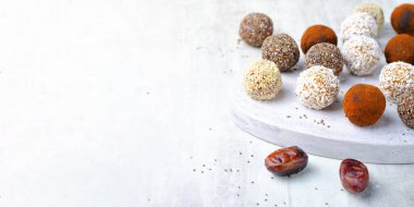 Çeşitli vejetaryen tatlılar, tohumlu lezzetli şeker topları, kurutulmuş meyve ve kakao tozu, Chia ile sağlıklı şeker, Susam tohumu, Hindistan cevizi ve yer mantarı.