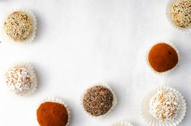 Çeşitli vejetaryen tatlılar, tohumlu lezzetli şeker topları, kurutulmuş meyve ve kakao tozu, Chia ile sağlıklı şeker, Susam tohumu, Hindistan cevizi ve yer mantarı.