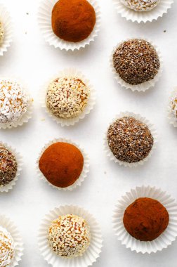 Çeşitli vejetaryen tatlılar, tohumlu lezzetli şeker topları, kurutulmuş meyve ve kakao tozu, Chia ile sağlıklı şeker, Susam tohumu, Hindistan cevizi ve yer mantarı.