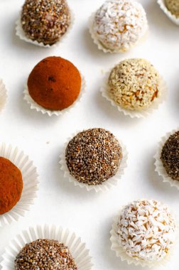 Çeşitli vejetaryen tatlılar, tohumlu lezzetli şeker topları, kurutulmuş meyve ve kakao tozu, Chia ile sağlıklı şeker, Susam tohumu, Hindistan cevizi ve yer mantarı.