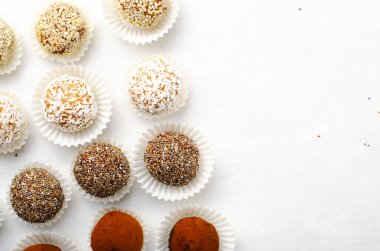 Çeşitli vejetaryen tatlılar, tohumlu lezzetli şeker topları, kurutulmuş meyve ve kakao tozu, Chia ile sağlıklı şeker, Susam tohumu, Hindistan cevizi ve yer mantarı.