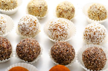 Çeşitli vejetaryen tatlılar, tohumlu lezzetli şeker topları, kurutulmuş meyve ve kakao tozu, Chia ile sağlıklı şeker, Susam tohumu, Hindistan cevizi ve yer mantarı.