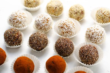 Çeşitli vejetaryen tatlılar, tohumlu lezzetli şeker topları, kurutulmuş meyve ve kakao tozu, Chia ile sağlıklı şeker, Susam tohumu, Hindistan cevizi ve yer mantarı.