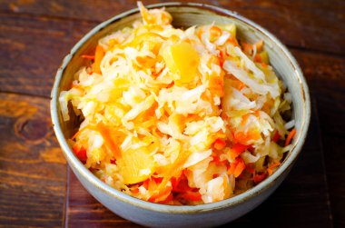 Sauerkraut, Shredded cabbage, apples, and carrots on dark rustic background, Healthy Eating, Fermented Food