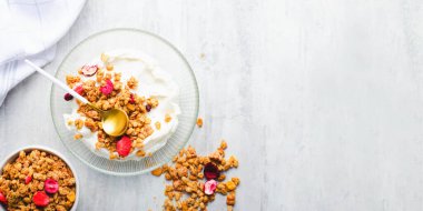 Granola with Yogurt in a Boal, Healthy Breakfast, Muesli with Dried Berries on Bright Background