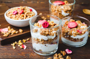 Granola and Yogurt Parfaits, Healthy Breakfast, Muesli with Dried Berries on Dark Wooden Background