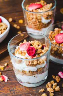 Granola and Yogurt Parfaits, Healthy Breakfast, Muesli with Dried Berries on Dark Wooden Background