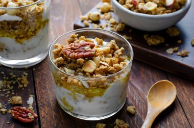 Granola ve Yoğurt Parfümleri, Sağlıklı Kahvaltı ya da Atıştırmalık Müsli Koyu Ahşap Arkaplanda Fındık Karışımı ve Bal