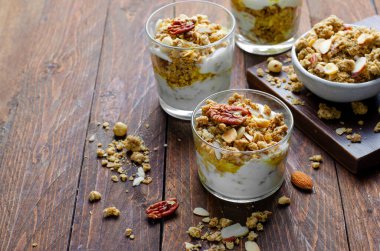 Granola ve Yoğurt Parfümleri, Sağlıklı Kahvaltı ya da Atıştırmalık Müsli Koyu Ahşap Arkaplanda Fındık Karışımı ve Bal