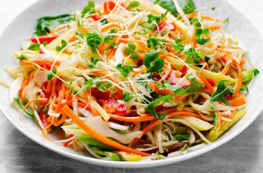 Lahanalı taze sebze salatası, dolmalık biber ve parlak arka planda havuç, vegan, sağlıklı beslenme.