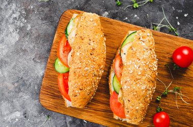 Izgara tavuk ve sebzeli sandviç, sağlıklı ve lezzetli aperatif, kahvaltı, akşam yemeği veya Karanlık Arkaplanda öğle yemeği