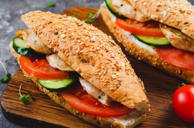 Izgara tavuk ve sebzeli sandviç, sağlıklı ve lezzetli aperatif, kahvaltı, akşam yemeği veya Karanlık Arkaplanda öğle yemeği