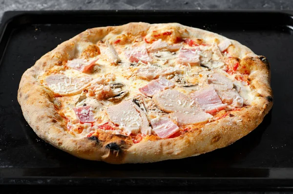 Frozen Chicken Mushroom Pizza on Dark Background, Stone Baked Pizza Ready to Bake
