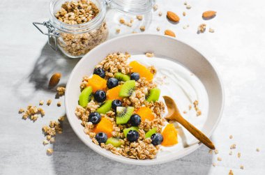 Granola, Kiwi, Yaban mersini ve Portakallı Yoğurt, Sağlıklı Atıştırmalık veya Parlak Arkaplanda Kahvaltı