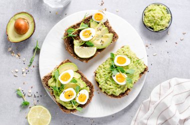 Avokado ve bıldırcın yumurtası tostları, sağlıklı atıştırmalıklar ya da Parlak Arkaplanda Kahvaltı