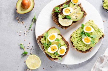 Avokado ve bıldırcın yumurtası tostları, sağlıklı atıştırmalıklar ya da Parlak Arkaplanda Kahvaltı